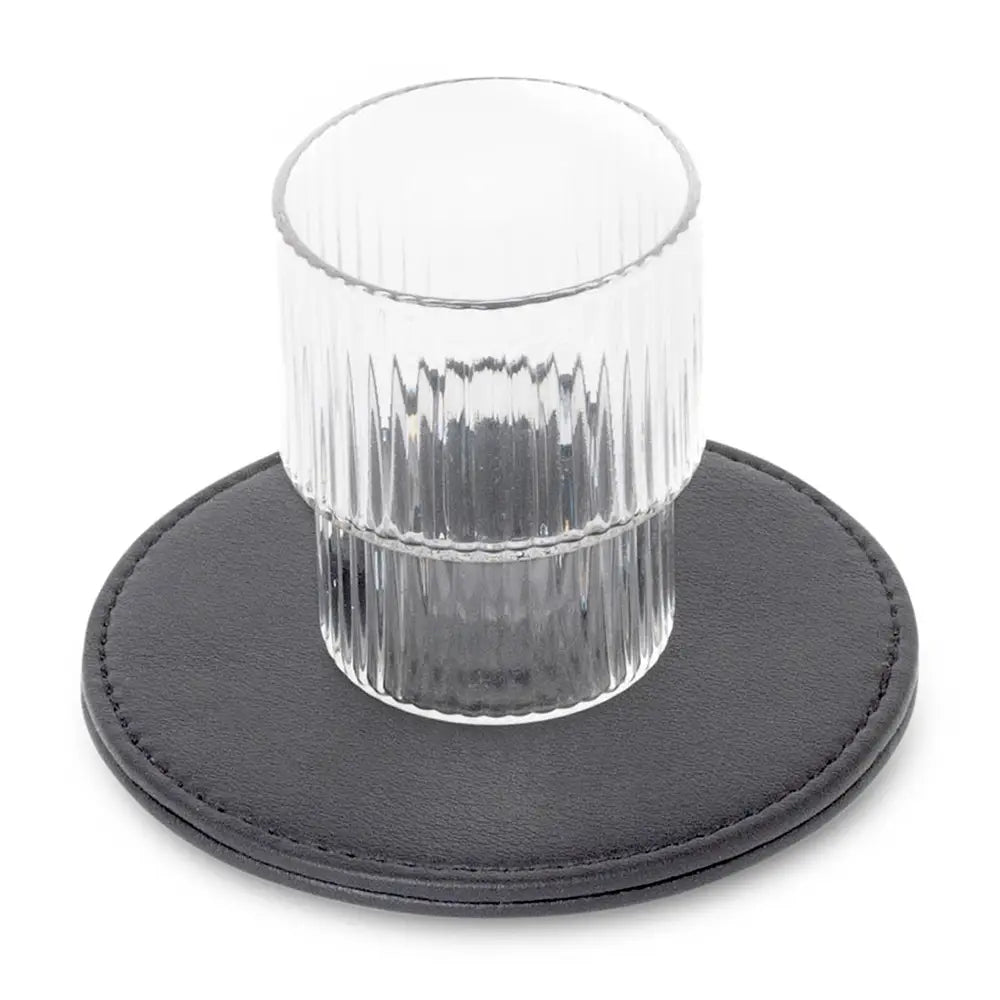 Clear glass on a black round coaster with a white background