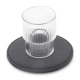 Clear glass on a black round coaster with a white background