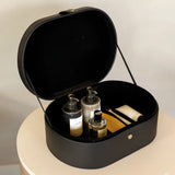 Black storage case with toiletries on a light background