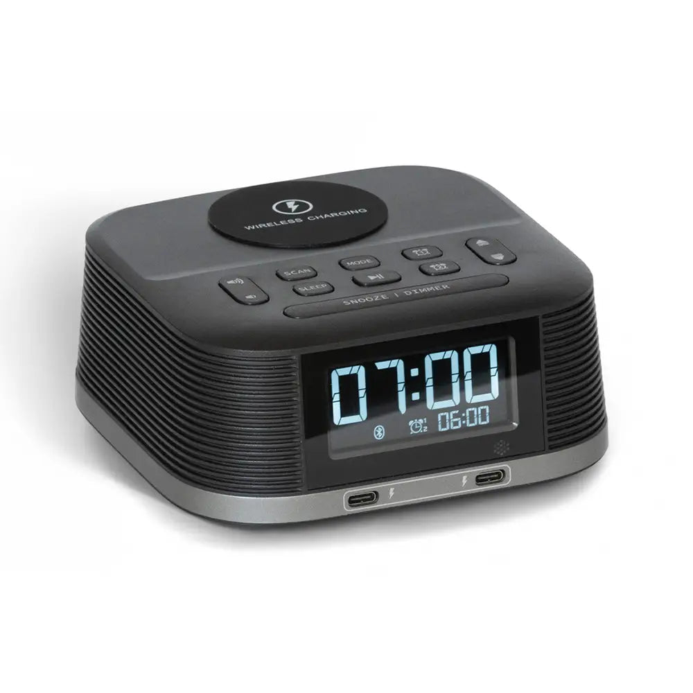 Black digital clock with wireless charging pad on a white background