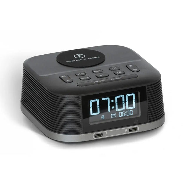 Black digital clock with wireless charging pad on a white background