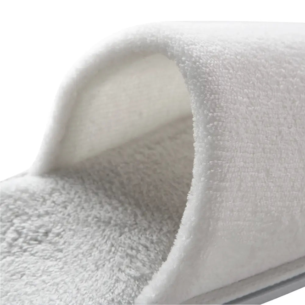 Close-up of a pair of white slippers with a soft texture on a white background