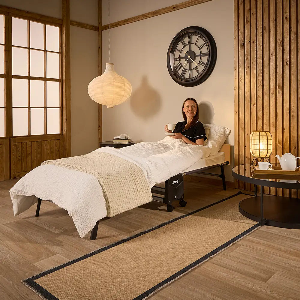 Woman sitting on a bed in a room with wooden walls and a large clock.