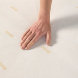 Hand placed on a mattess white surface