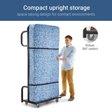 An upright hotel bed with a person demonstrating its size and features.