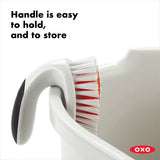 OXO cleaning brush with text 'Handle is easy to hold, and to store' on a white background