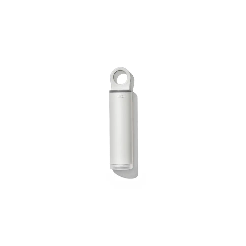 Oxo Lint Brush closed with a circular loop at the top, shown against a solid white background.