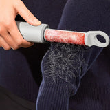Person using a lint roller to remove hair from a sweater