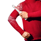 A person wearing a red knit sweater holds a lint roller against their upper arm, showing white pet hair being swept away. The background is solid white.
