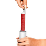 Hand holding a red and white roller against a white background