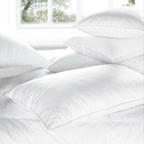 Luxury Recycled Down-Rich Pillows stacked on bed in white cotton covers