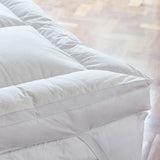 Close-up corner view of Out of Eden Luxury Down Dual Layer Mattress Topper showing box-stitch channels and elasticated strap