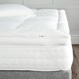 Dùsal Luxury Down Dual Layer Mattress Topper fitted on a bed with elasticated corner strap