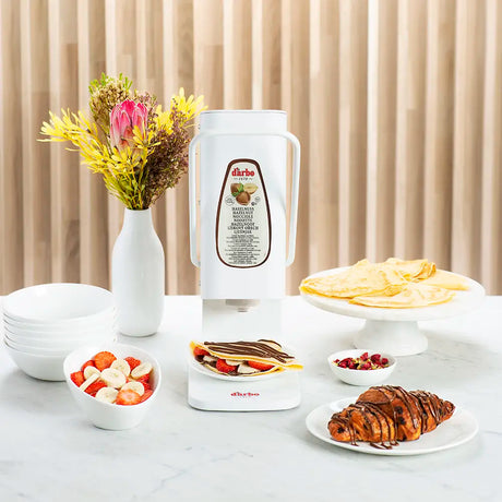 Darbo dispenser on a breakfast table with crepes, croissants and fresh fruit