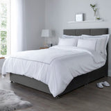 Corded Oxford bedsheets set on a gray bed frame in a bright bedroom.