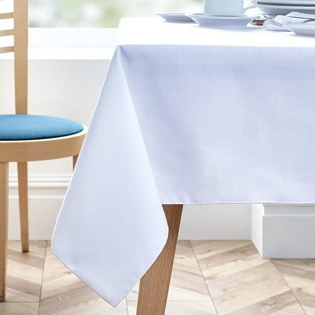 Easycare Polyester Square Tablecloth on a dining table with chairs in a bright room.