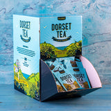 Dorset Tea packaging with scenic design on a textured blue background