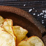 Close-up of Yorkshire Crisps on a wooden plate with salt crystals