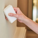 Magic sponge wiping a mark on a wall away