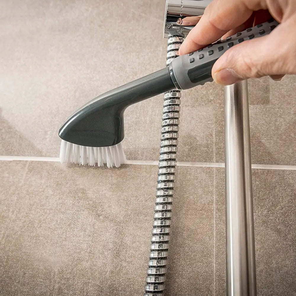Comfi Grip Tile & Grout Brush - black brush with ergonomic handle and white brussels being used to clean a bathroom