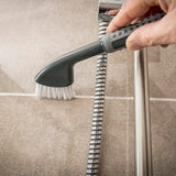 Comfi Grip Tile & Grout Brush - black brush with ergonomic handle and white brussels being used to clean a bathroom