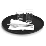 Black tray with white napkin, cutlery, and two glasses on a white background