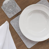 Heat Resistant Melamine Placemat with a glass and folded napkin on a wooden table.