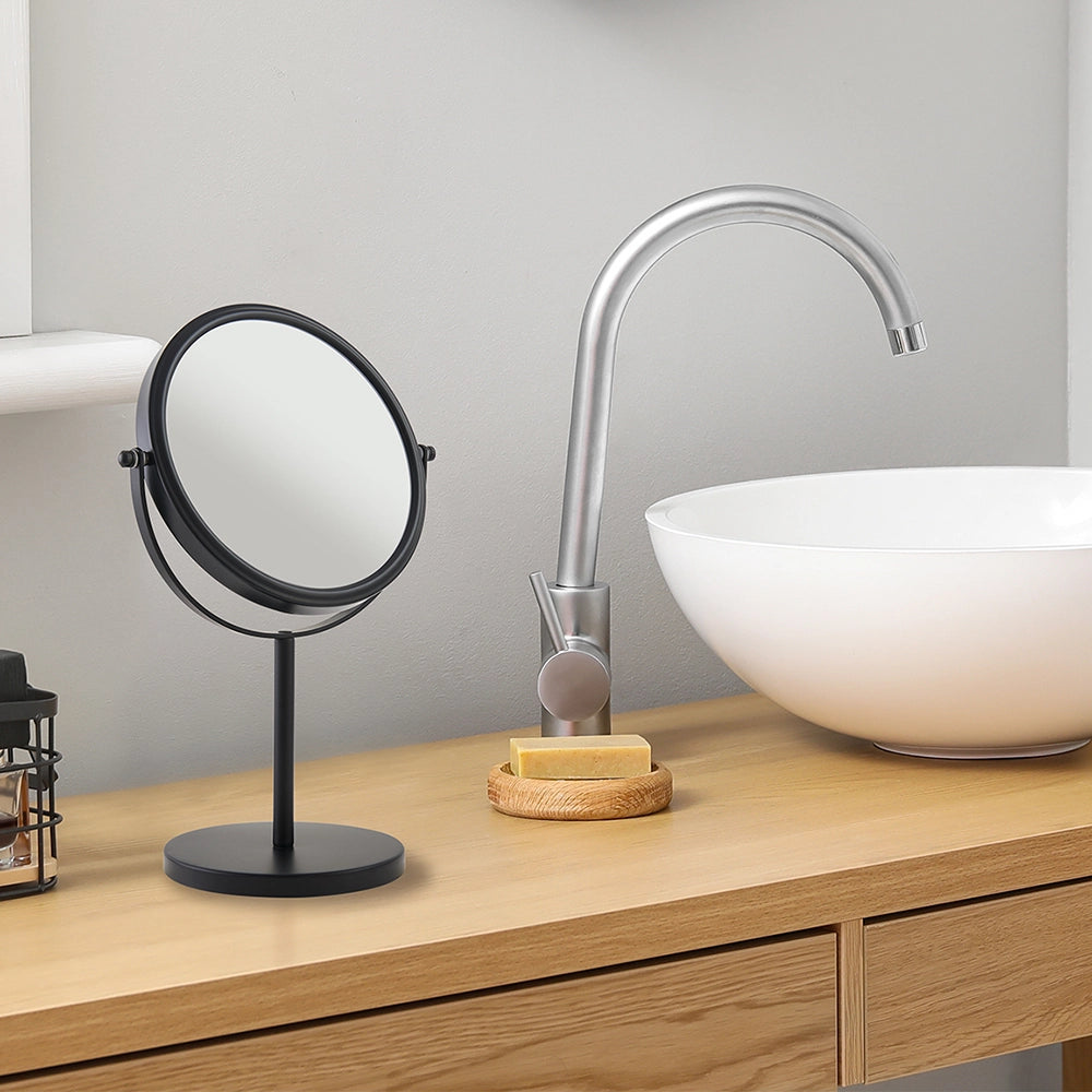 Bathroom vanity with a round mirror, faucet, and soap dish.