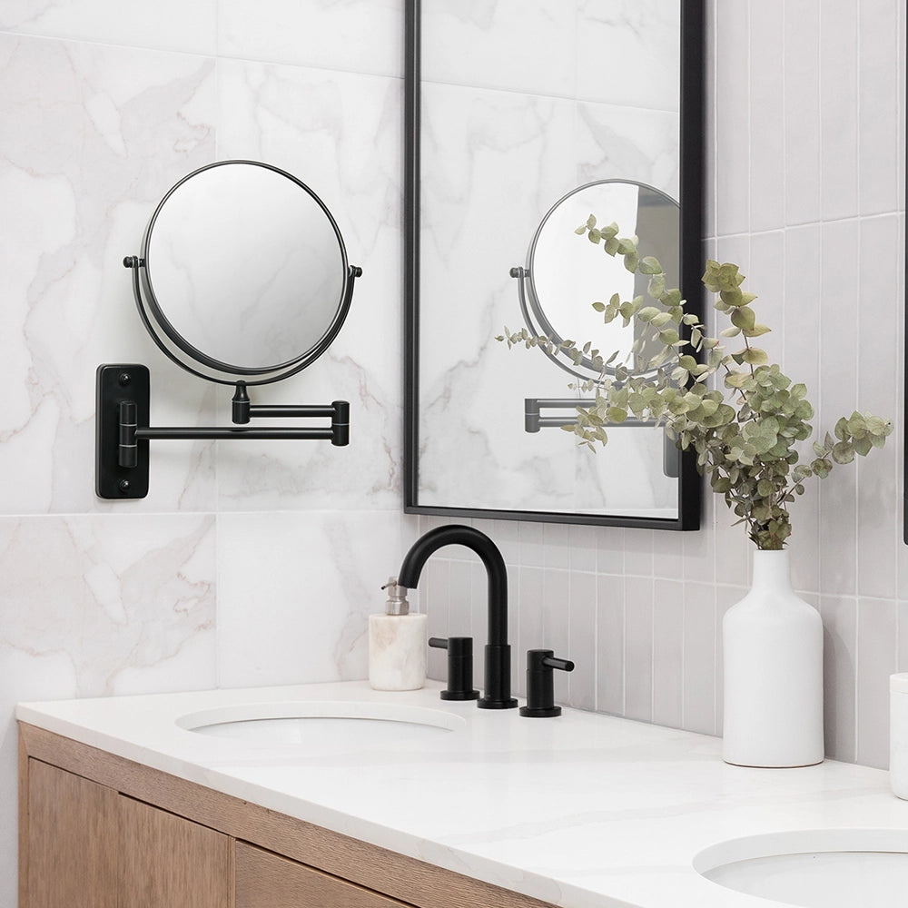 Bathroom vanity with black faucet, round mirror, and wall-mounted magnifying mirror.
