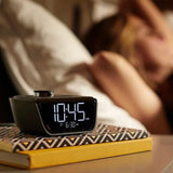 Cubie Wink Hotel Alarm Clock & Charger clock on a book with a blurred background