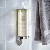 Hand wash bottle labeled 'eden' on a tiled wall with a towel