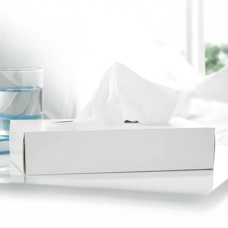 White tissue box on a white surface with a blurred background