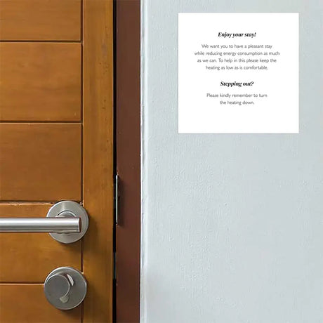 Wooden door with a Adhesive Energy Saving & Heating Notice on white ground on a gray wall