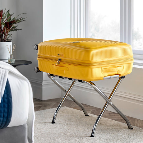 Chrome luggage rack with yellow suitcase on the stand