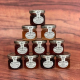 Pyramid of jam jars with visible brand labels on a wooden surface