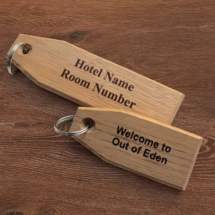 Two wooden key tags with engraved text on a wooden surface